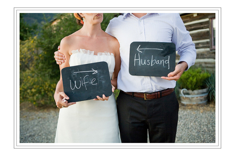 bride and groom with chalkboard signs 