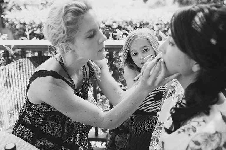 Flower girl watching the bride get her make up done