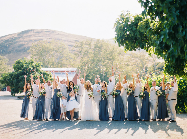 Bridal party throwing confetti in the air 