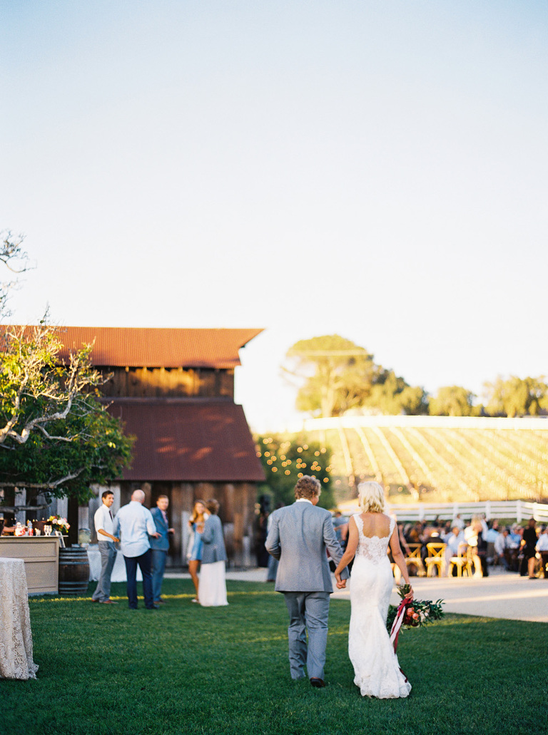 Newlyweds walking back into their greengate ranch and vineyard wedding reception 