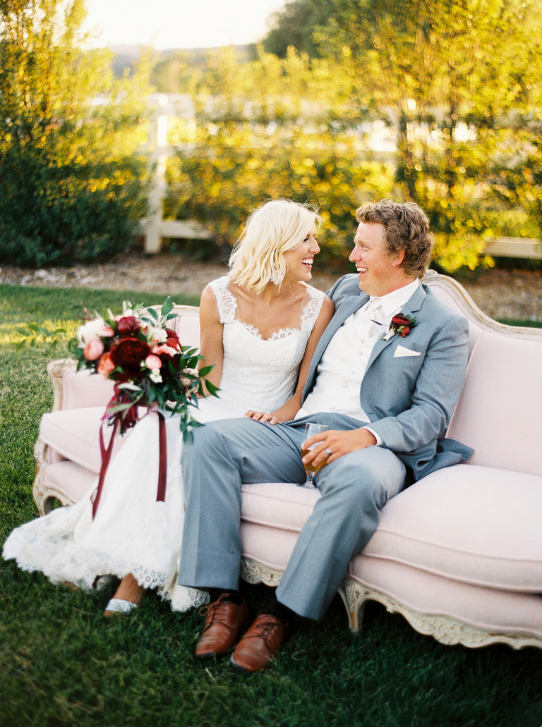 Bride and groom on pink rental sofa from embellish vintage rentals 