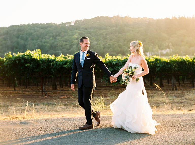 Just married and walking hand in hand at sunset. 