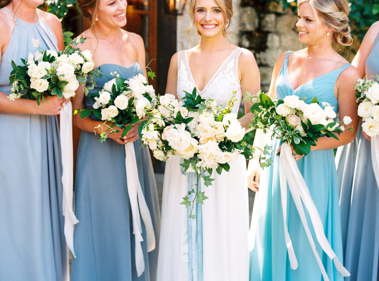 Bride holding her large free-flowing bridal bouquet with long blue ribbons